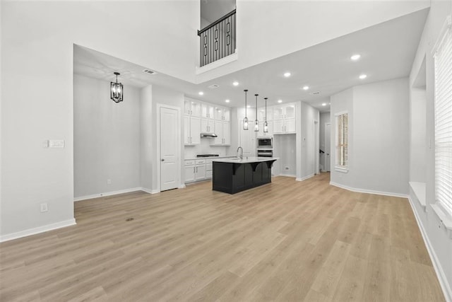 2666 Woodforest Pkwy N, Montgomery, TX 77316 - unfurnished living room featuring light wood finished floors, baseboards, a chandelier, recessed lighting, and a sink