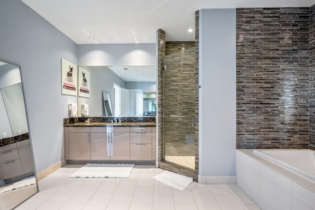 full bath with vanity, a garden tub, a shower stall, baseboards, and tile patterned floors