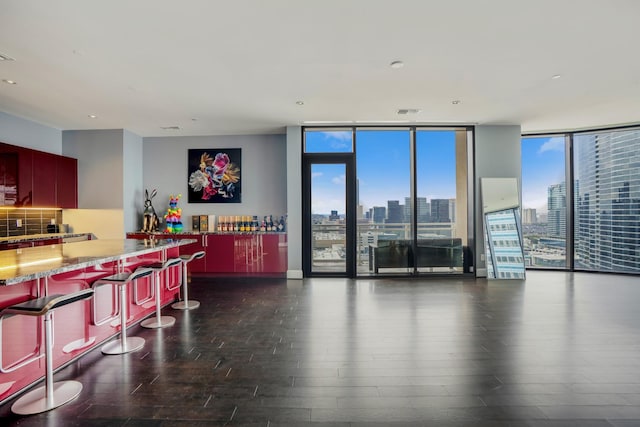 bar featuring dark wood finished floors, a wall of windows, backsplash, and a city view