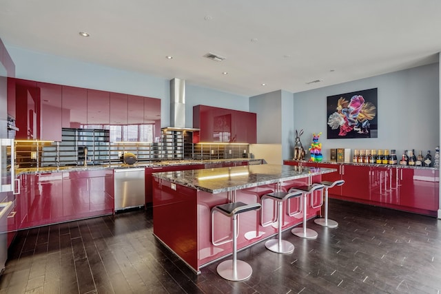 kitchen with wall chimney range hood, stainless steel dishwasher, a kitchen bar, visible vents, and modern cabinets