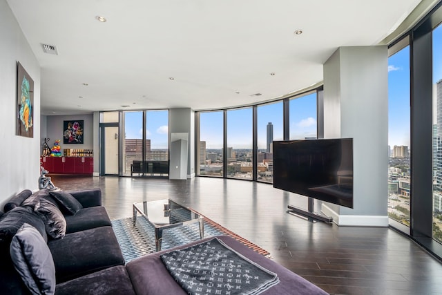 living area with baseboards, visible vents, wood finished floors, and floor to ceiling windows