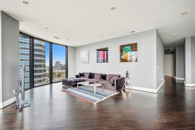 living area featuring dark wood-style floors, expansive windows, baseboards, visible vents, and a view of city