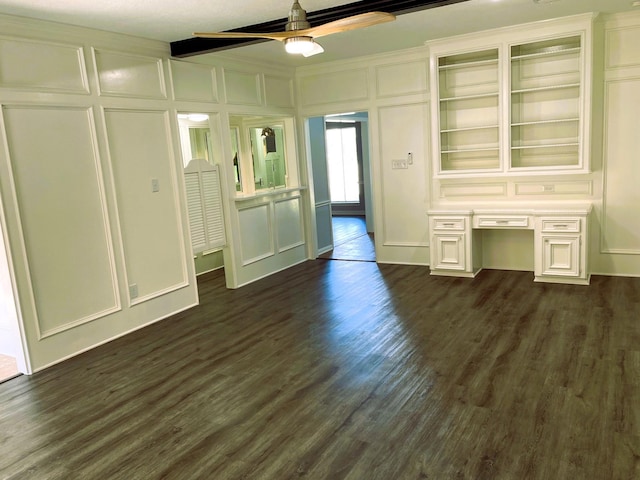 interior space featuring a decorative wall, dark wood-type flooring, and built in study area