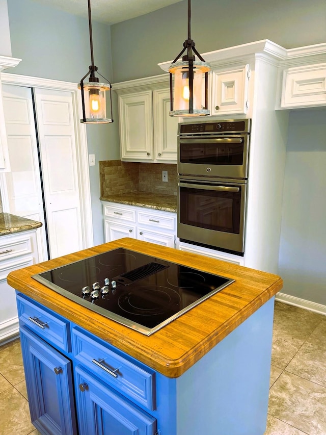 kitchen with black electric stovetop, butcher block counters, white cabinetry, and blue cabinets