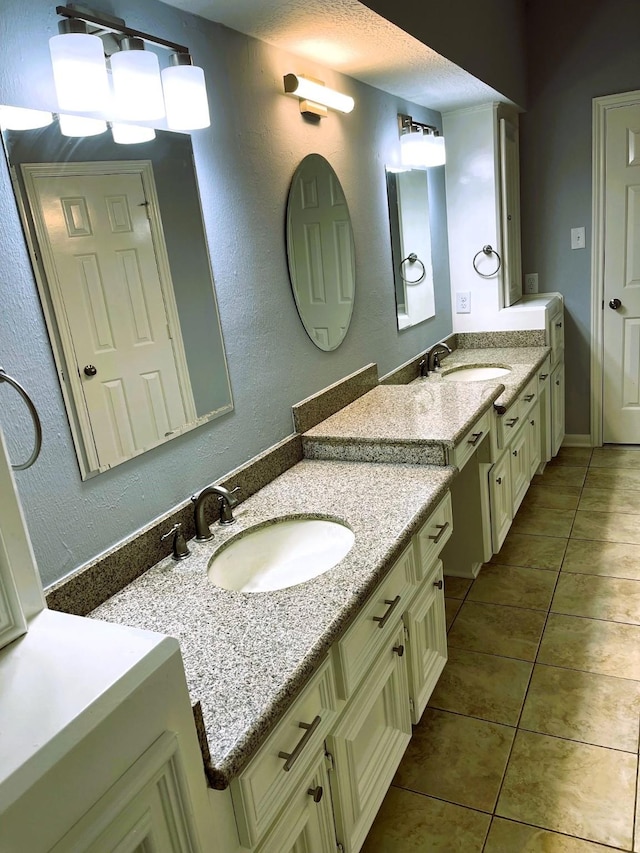 full bathroom with two vanities, a sink, and tile patterned floors