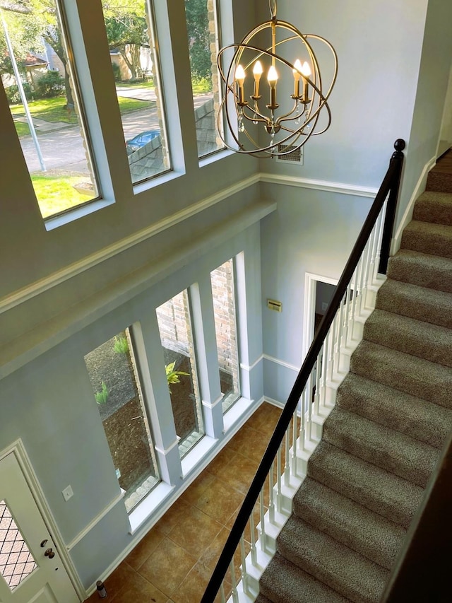 stairs with baseboards, a notable chandelier, and tile patterned floors