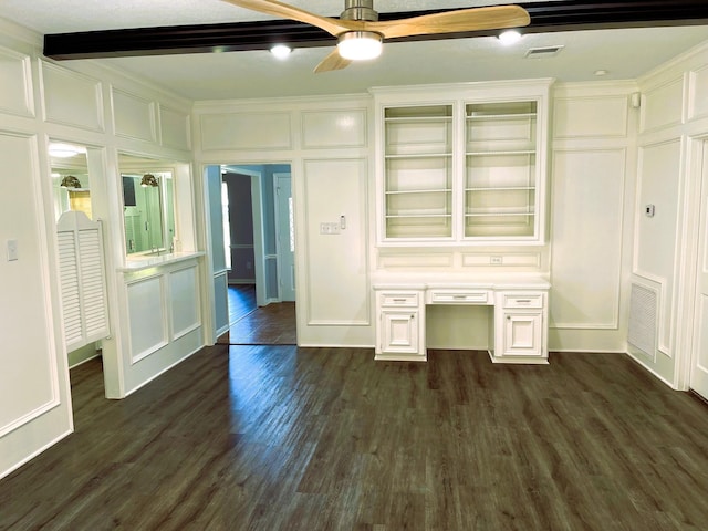 unfurnished bedroom with dark wood-style flooring, built in study area, visible vents, and a decorative wall