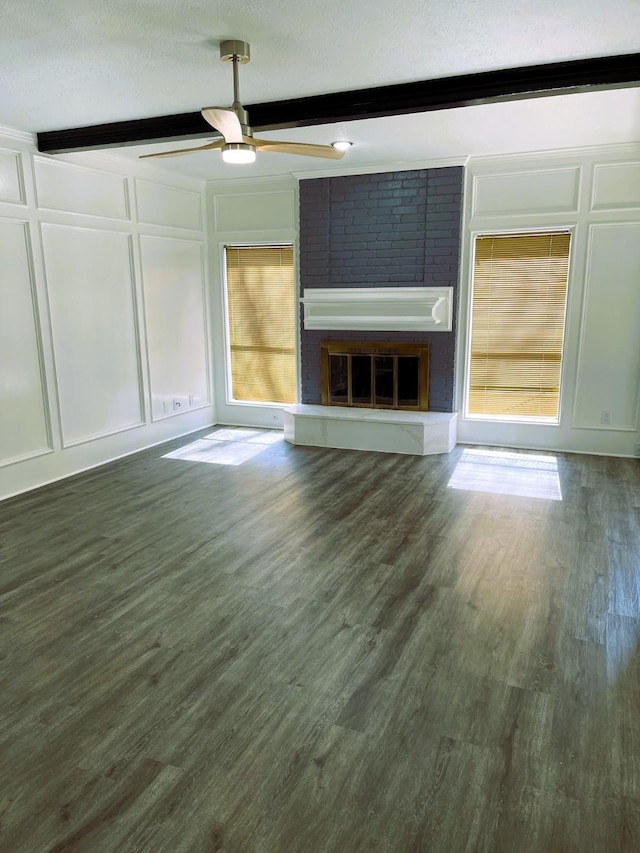 unfurnished living room featuring dark wood-style floors, a fireplace, a decorative wall, and beam ceiling