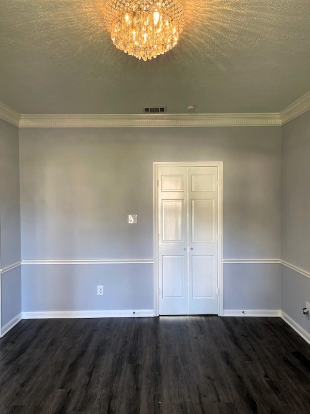 spare room with dark wood-style floors, a textured ceiling, a chandelier, and baseboards