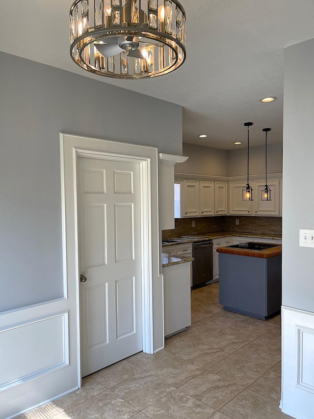 kitchen featuring black dishwasher, white cabinets, butcher block counters, decorative light fixtures, and a notable chandelier