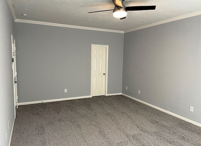 spare room featuring dark carpet, ornamental molding, ceiling fan, a textured ceiling, and baseboards