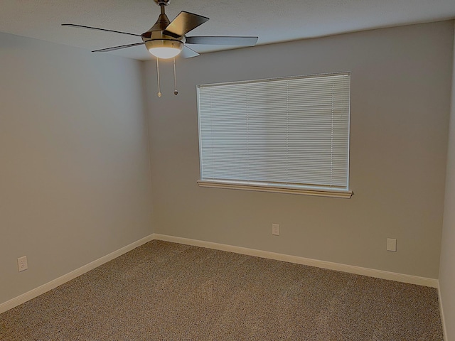 unfurnished room with carpet, baseboards, and a ceiling fan