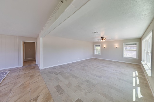 spare room with visible vents, a ceiling fan, baseboards, a textured ceiling, and light wood-type flooring