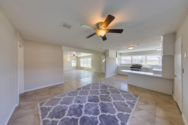 interior space with a sink, visible vents, a ceiling fan, and light tile patterned floors