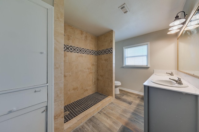 full bathroom with a sink, visible vents, wood finished floors, and double vanity