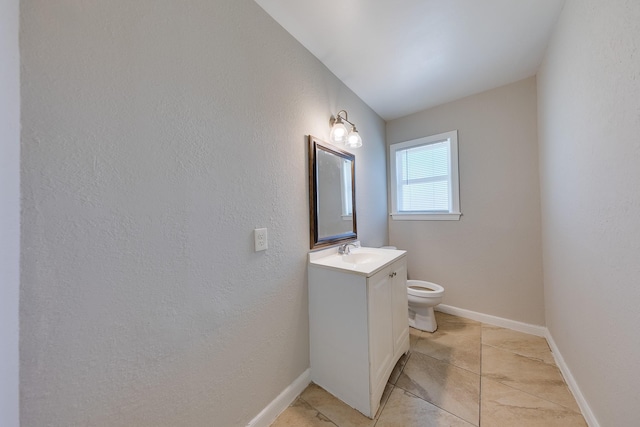 half bath featuring vanity, toilet, baseboards, and tile patterned flooring