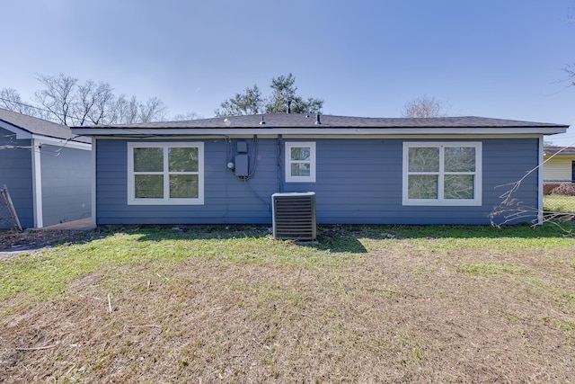 back of house featuring central AC and a lawn