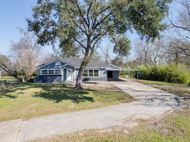single story home with concrete driveway, a front yard, an attached carport, and fence