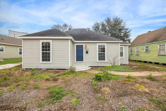 view of front of home with entry steps and a shingled roof