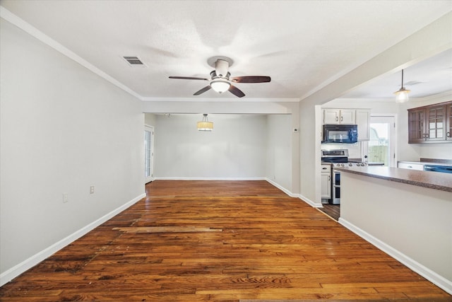 unfurnished living room with dark wood-style floors, visible vents, crown molding, and baseboards