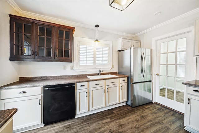 kitchen with hanging light fixtures, glass insert cabinets, freestanding refrigerator, a sink, and dishwasher