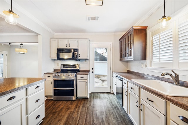 kitchen with visible vents, appliances with stainless steel finishes, glass insert cabinets, hanging light fixtures, and a sink