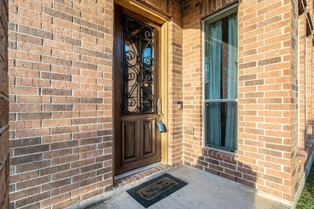 doorway to property with brick siding