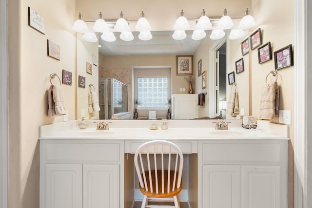 bathroom featuring a sink, a shower stall, and double vanity