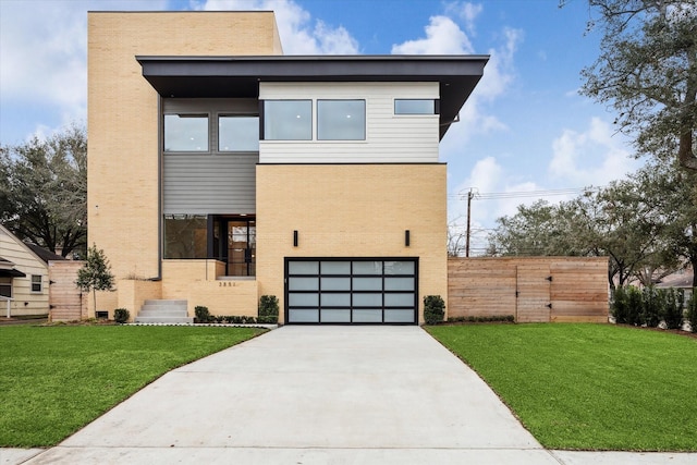 contemporary home with driveway, an attached garage, fence, a front lawn, and brick siding