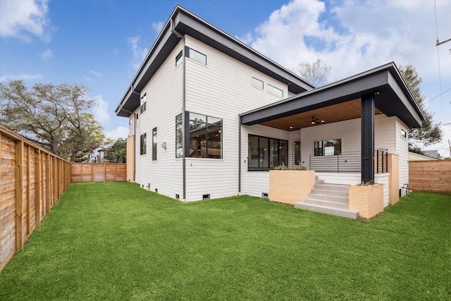 back of property featuring a fenced backyard, ceiling fan, crawl space, and a yard