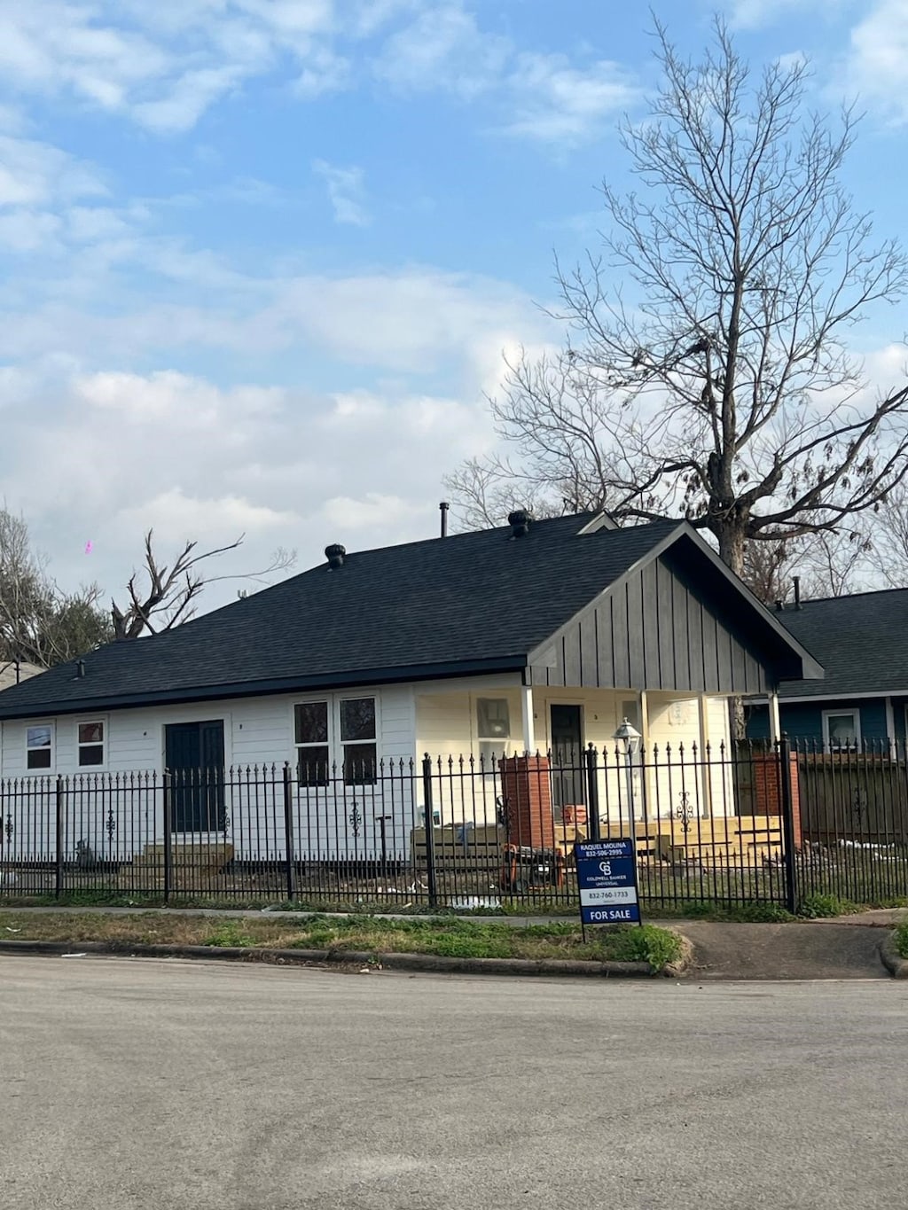 view of front of home featuring board and batten siding, a fenced front yard, and a shingled roof