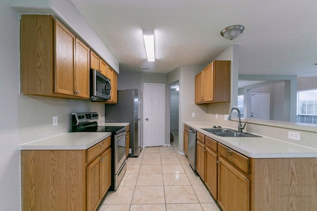 kitchen featuring a sink, brown cabinets, stainless steel appliances, and light countertops