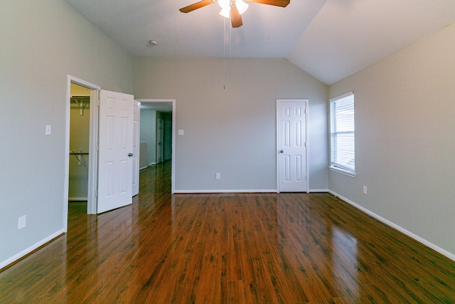 unfurnished bedroom featuring vaulted ceiling, baseboards, and dark wood finished floors