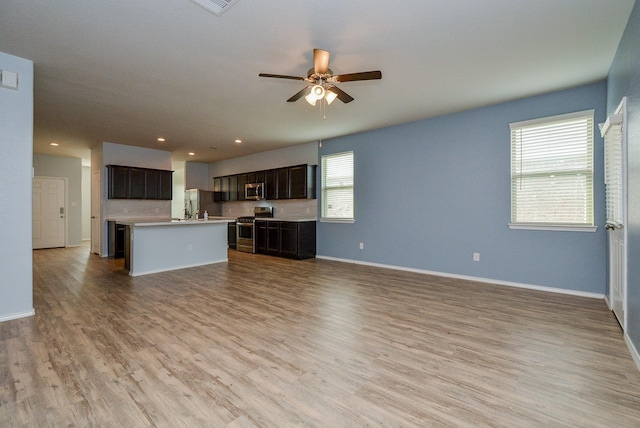 unfurnished living room with ceiling fan, recessed lighting, baseboards, and light wood-style floors