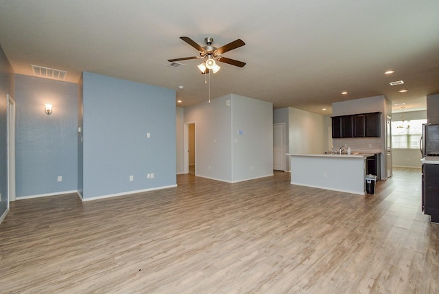 unfurnished living room with light wood finished floors, visible vents, and a ceiling fan