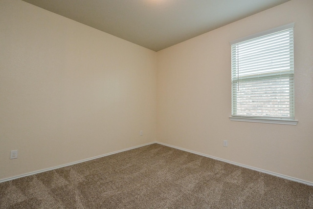 carpeted empty room with baseboards