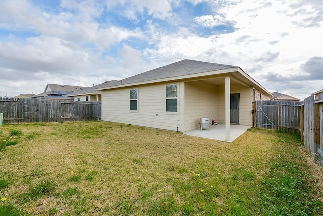 rear view of property featuring a patio, a lawn, and a fenced backyard