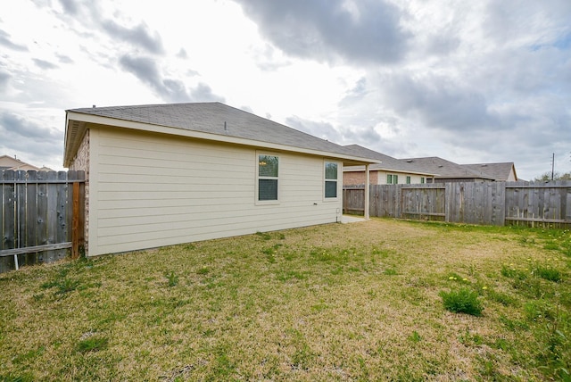 back of house with a yard and a fenced backyard