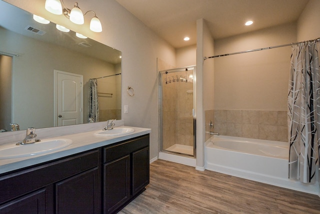 bathroom featuring a bath, wood finished floors, a sink, and visible vents