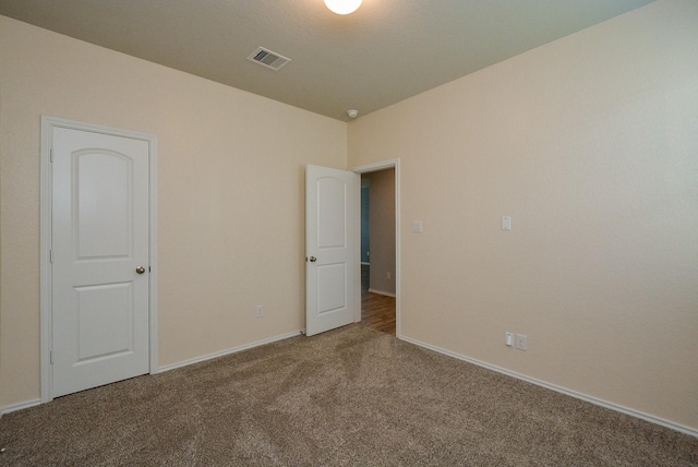 carpeted empty room featuring visible vents and baseboards