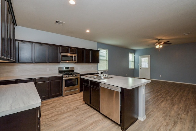 kitchen with visible vents, light countertops, appliances with stainless steel finishes, and a kitchen island with sink