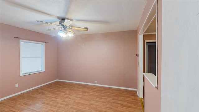 unfurnished room featuring ceiling fan, light wood finished floors, and baseboards