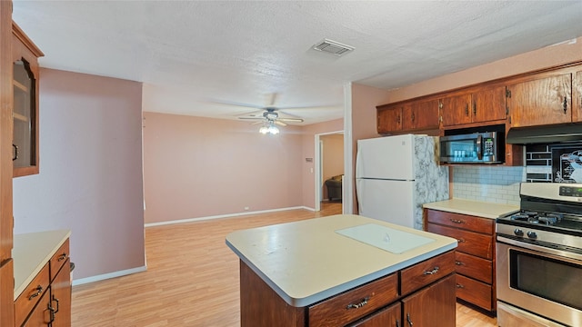 kitchen with stainless steel appliances, light countertops, visible vents, and decorative backsplash