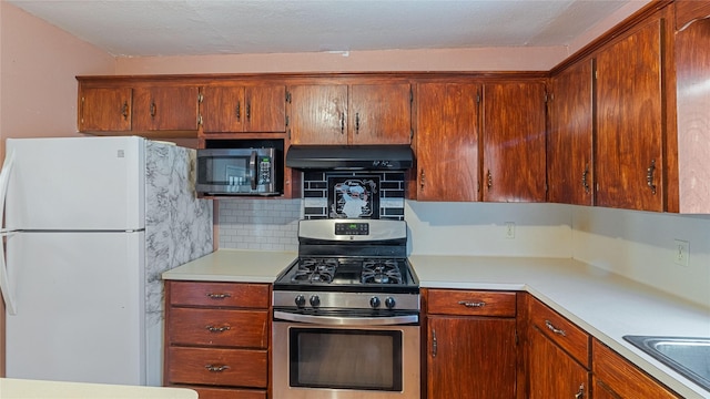 kitchen with stainless steel appliances, decorative backsplash, light countertops, and under cabinet range hood