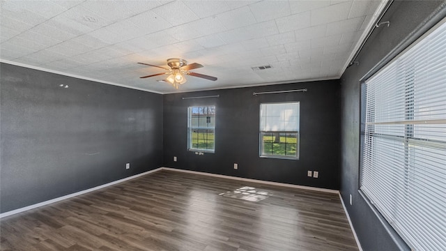 unfurnished room featuring ornamental molding, wood finished floors, visible vents, and baseboards