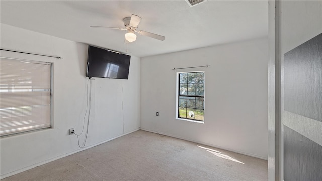 carpeted empty room with a ceiling fan