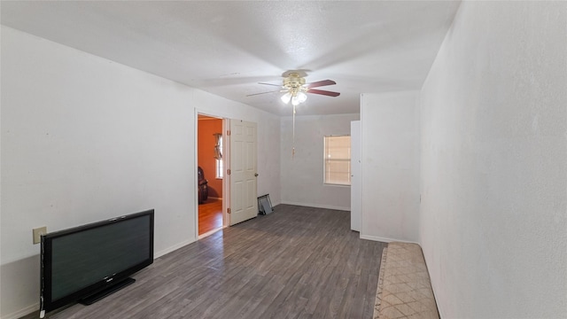 unfurnished room with ceiling fan, wood finished floors, and baseboards