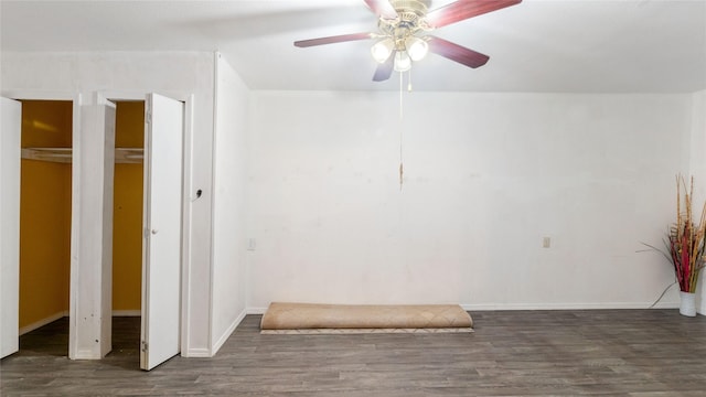 empty room with a ceiling fan, baseboards, and wood finished floors