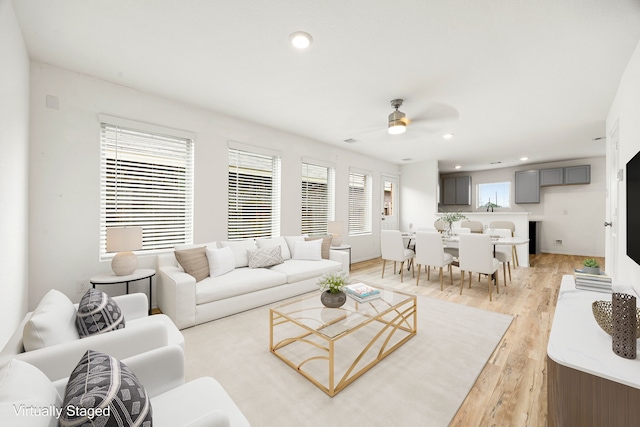 living room with recessed lighting, ceiling fan, and light wood-style flooring