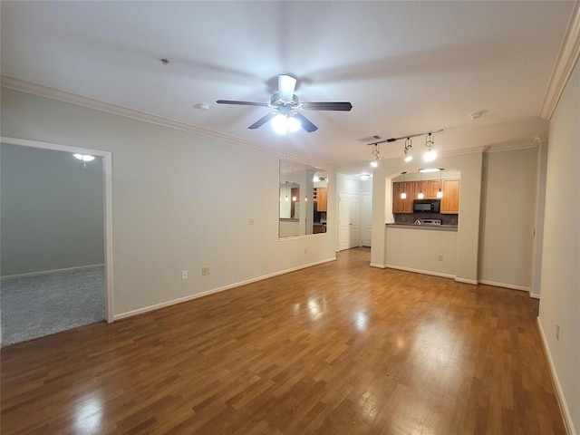 unfurnished living room featuring baseboards, dark wood-style flooring, a ceiling fan, and crown molding